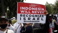 A woman holds up a poster during a rally against Israel's attacks on Gaza, outside the U.S. Embassy in Jakarta, Indonesia, May 21, 2021.