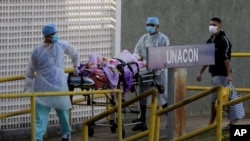 Trabajadores de la salud reciben a otro paciente sospechoso de tener el COVID-19 en el Hospital Universitario de Brasilia el 5 de agosto.