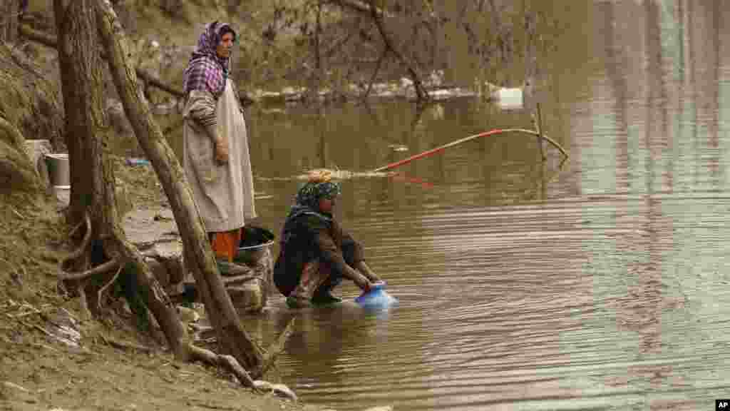 Les femmes du village du Kashmiri recueillent l'eau d'une rivière, à l'occasion de la Journée mondiale de l'eau à Dasilpora, en Inde, le 22 mars 2017.