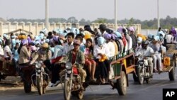 File Photo: Cambodian garment factory workers travel together in motor carts to get home from work at the Sala Lek Pram village, Kampong Chhnang province.
