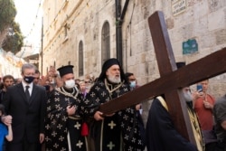 Fieles ortodoxos griegos recorren la Vía Dolorosa para volver sobre el camino que tomó Jesucristo el día de su crucifixión, durante la Semana Santa ortodoxa, en la Ciudad Vieja de Jerusalén, el viernes 30 de abril de 2021.