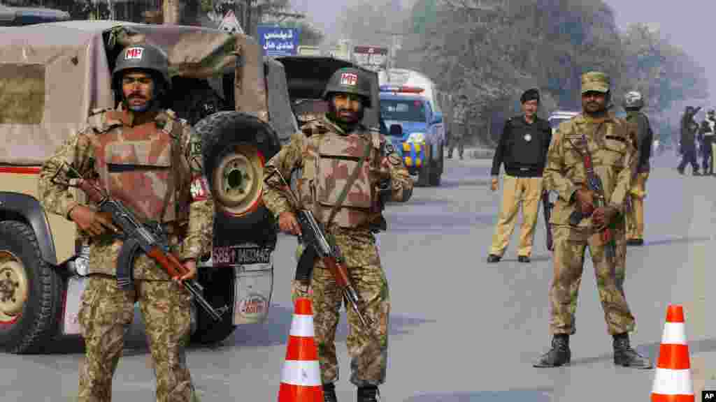 Pakistani army troops cordon off a road leading to a school under attack by Taliban gunmen in Peshawar, Pakistan, Dec. 16, 2014.