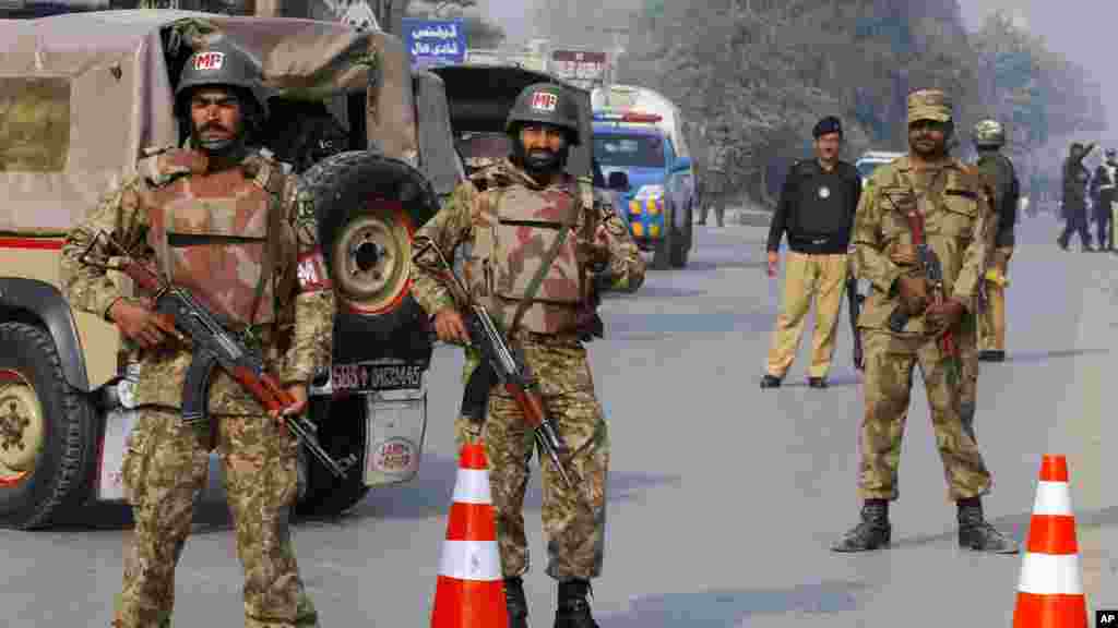 Les troupes de l'armée pakistanaise ont fait un cordon de sécurité sur la route menant à l'école qui a été l'objet d'une attaque des talibans armé sà Peshawar, Pakistan, le 16 décembre 2014.