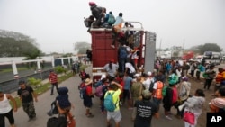Central American migrants pack into the back of a trailer truck as they begin their morning trek as part of a thousands-strong caravan hoping to reach the U.S. border, in Isla, Veracruz state, Mexico, Sunday, Nov. 4, 2018.