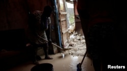 Des sinistrés tentent d'extirper la boue de leur maison endommagée après le passage de l'ouragan Matthew sur la ville de Jérémie, Haïti, 6 octobre 2016.