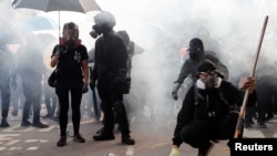 香港中文大学的学生们站在防暴警察发射的催泪弹烟雾中。（2019年11月12日）