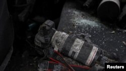 Kamera milik seorang jurnalis, yang diselimuti debu dan pecahan kaca, tergeletak di kursi belakang dari sebuah mobil yang hancur akibat serangan rusal Rusia di Kharkiv, Ukraina, pada 11 Januari 2024. (Foto: Reuters/Sofiia Gatilova)