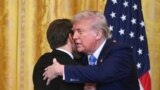 Дональд Трамп и Эммануэль Макрон завершают пресс-конференцию в Белом доме дружескими объятиями. 24 февраля 2025 года. (Photo by ROBERTO SCHMIDT / AFP).