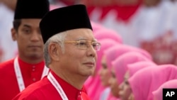 President of the ruling United Malays National Organisation (UMNO) and Malaysia's Prime Minister Najib Razak inspects a ceremonial guard of honor during the opening ceremony of the party's general assembly in Kuala Lumpur, Malaysia on Thursday, Dec. 10, 2