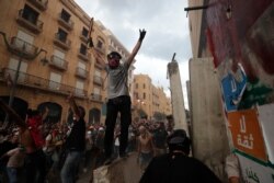 Protesters celebrate after removing a concrete slab from a barrier to open a road leading to the parliament building during demonstrations following the Aug. 4, 2020, massive explosion which devastated Beirut, Lebanon, Aug. 10, 2020.