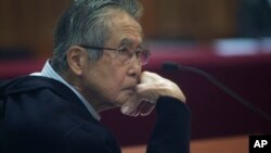 FILE - Former President Alberto Fujimori, photographed through a glass window, attending his trial at a police base on the outskirts of Lima, Peru, June 28, 2016.