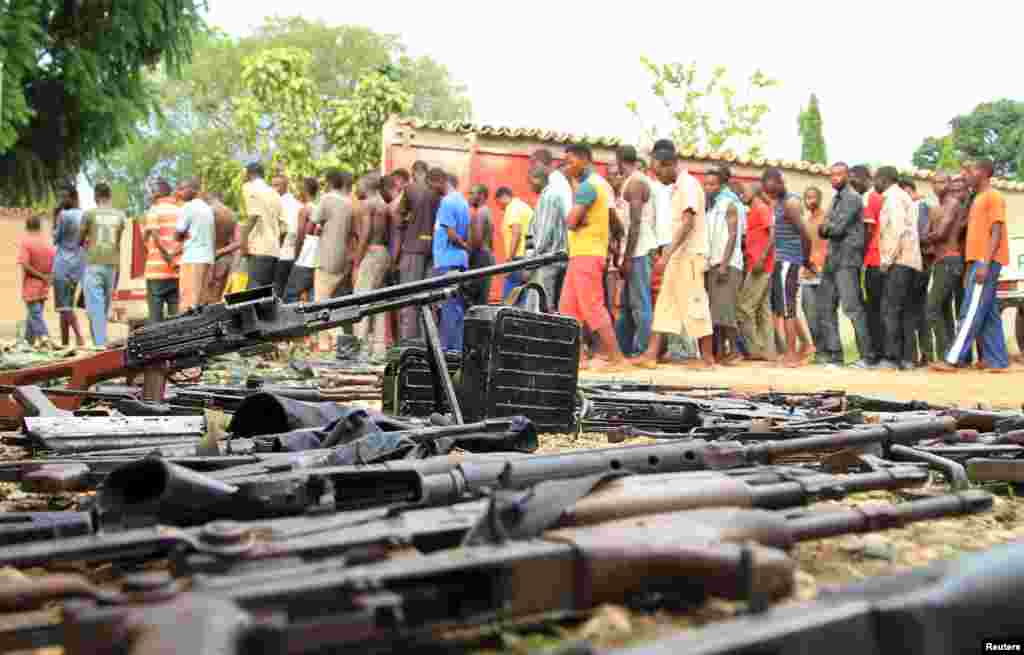 Des combattants présumés sont exhibés devant les médias par la police burundaises près d'une cache d'armes découverte après des affrontements dans la capitale Bujumbura, au Burundi, 12 décembre 2015.
