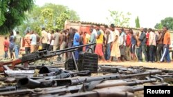 Des insurgés présumés sont exhibés devant les médias par la police burundaise près d'une cache d'armes récupérées après des affrontements dans la capitale Bujumbura, au Burundi, le 12 décembre 2015.