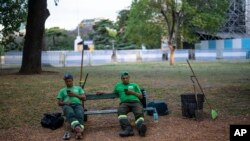 Limpiadores de calles toman un descanso en una plaza de la Ciudad de Buenos Aires, el 7 de diciembre de 2022. 