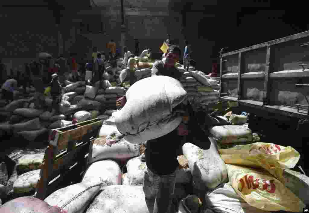 Survivors carry bags of rice from a warehouse they stormed to get food after the typhoon, Tacloban city, Leyte province, central Philippines, Nov. 11, 2013.
