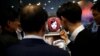 FILE - Attendees interact with Commerce Bot, a robot that provides customer service with artificial intelligence technology and voice recognition, at SK telecom's stand at the Mobile World Congress in Barcelona, Spain, Feb. 28, 2017. 