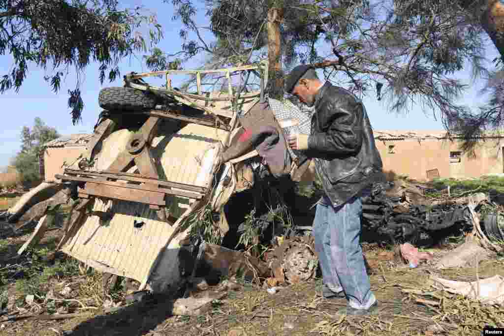 A man looks at the scene near a military base 50 km outside Benghazi, after a suicide bomber detonated a truck packed with explosives at an army checkpoint, Barsis, Libya, Dec. 22, 2013. 