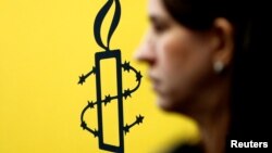 La militante des droits des femmes, Luisa Kislinger, devant le logo d'Amnesty International à Caracas au Venezuela le 20 février 2019.