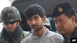 Polisi mengawal tersangka pelaku pemboman Yusufu Mieraili, tengah, yang ditangkap minggu lalu dekat perbatasan dengan Kamboja ketika ia diserahkan dari militer ke polisi di markas besar polisi di Bangkok, Thailand, 7 September 2015. 