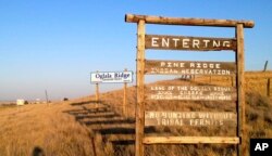 FILE - A sign hangs outside the entrance to Pine Ridge Indian Reservation in South Dakota, home to the Oglala Sioux Tribe, Sept. 9, 2012. Tribal leaders in South Dakota have denounced Governor Kristi Noem’s suggestion that drug cartels operate on reservation land.