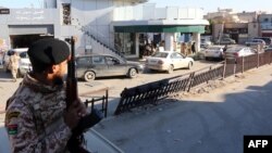 Un soldat de l'armée libyenne monte la garde devant une station-service dans la capitale Tripoli le 14 décembre 2013.