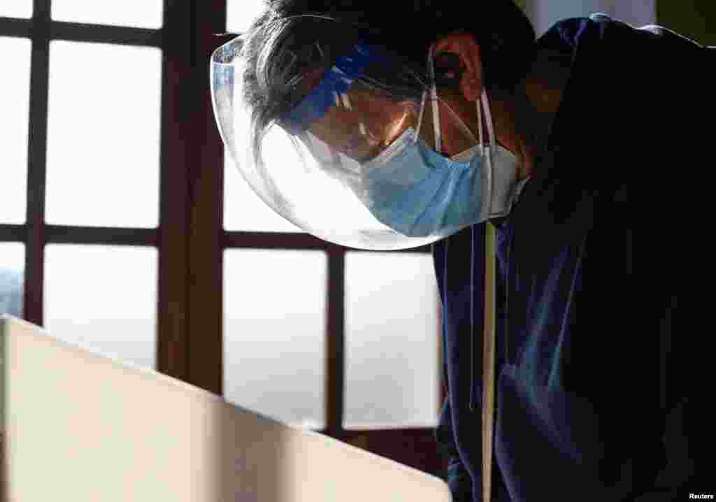 Un hombre, usando una doble protección por la pandemia del COVID-19, emite su voto en un colegio electoral durante las elecciones presidenciales, en Quito, Ecuador, el 7 de febrero de 2021.