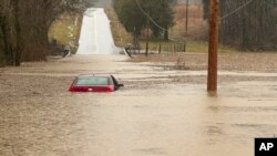 ARCHIVO - Esta imagen proporcionada por el Departamento de Policía del condado Warren, Kentucky, muestra un auto parcialmente sumergido en las afueras de Bowling Green, Kentucky, el 15 de febrero de 2025. 