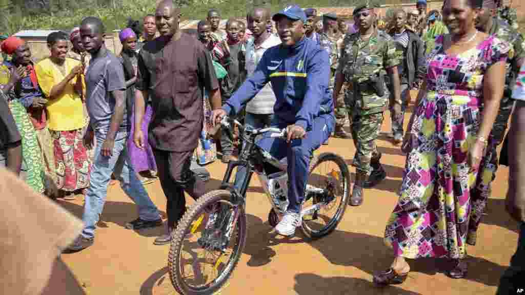 Pierre Nkurunziza arrive à bicyclette, accompagné par la Première dame burundaise, Denise Bucumi Nkurunziza, pour voter, Ngozi, 21 juillet 2015.