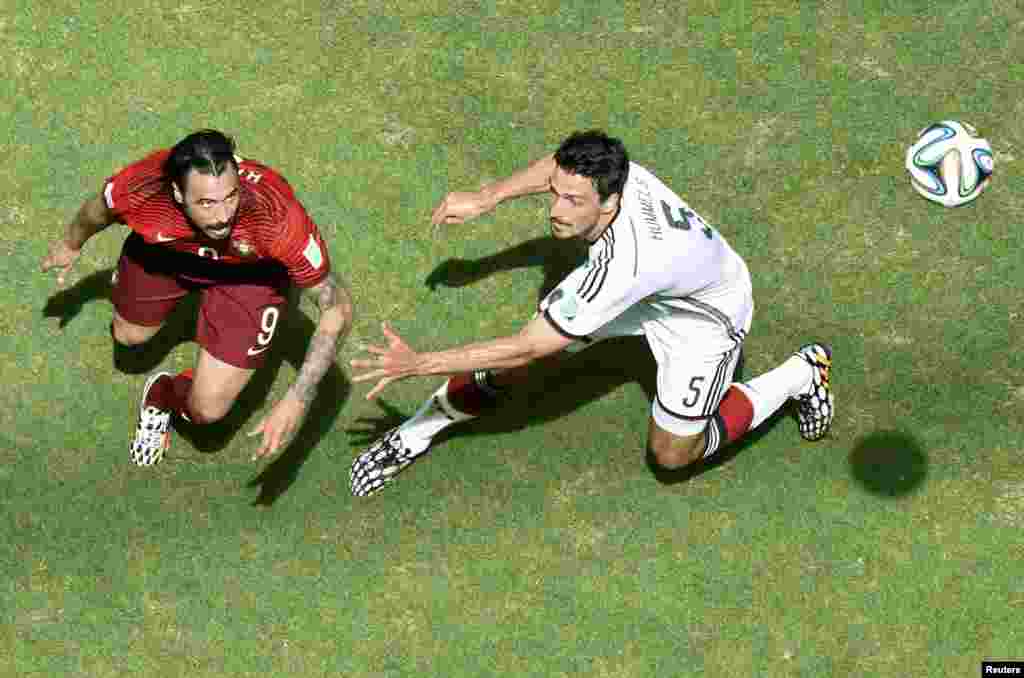 Portugal's Hugo Almeida fights for the ball with Germany's Mats Hummels during their 2014 World Cup Group G soccer match at the Fonte Nova arena in Salvador, June 16, 2014.