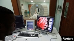 FILE - A doctor checks a screen showing a graphical representation of a human heart. A new study suggests that patients who see their clogged arteries are more likely to make and keep a heart-healthy lifestyle.