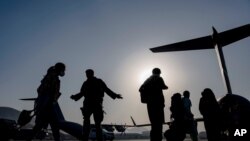 Angkatan Udara AS memandu para pengungsi di atas pesawat angkut di Bandara Internasional Hamid Karzai di Kabul, Afghanistan, 24 Agustus 2021. (Foto Angkatan Udara AS)
