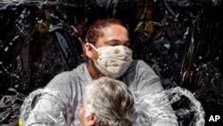A nurse and patient embrace in this cropped version of the image released by World Press Photo, April 15, 2021, by Mads Nissen, Politiken, Panos Pictures, which won the World Press Photo of the Year award.