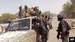 FILE - Cameroon soldiers check a truck on the border between Cameroon and Nigeria as they combat regional Islamic extremists including Boko Haram, Feb. 19, 2015.