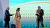 Singapore's Prime Minister Lee Hsien Loong, right gestures to Myanmar's Foreign Minister Aung San Suu Kyi, to move in closer for the group hand shake as Malaysia's Prime Minister Najib Razak, left, watches during the opening ceremony of the 28th and 29th ASEAN summits at National Convention Center in Vientiane, Laos, Tuesday, Sept. 6, 2016. 