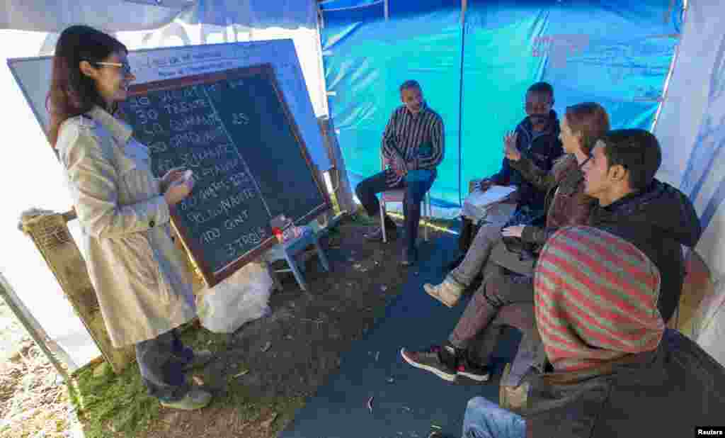 Europe's migration crisis has spilled over into a muddy park in Brussels where hundreds of migrants are camping in tents not far from the European Union's headquarters in one of the most visible signs of the urgency facing the bloc's officials. In this image, migrants attend French lessons at a makeshift camp outside the foreign office in Brussels.