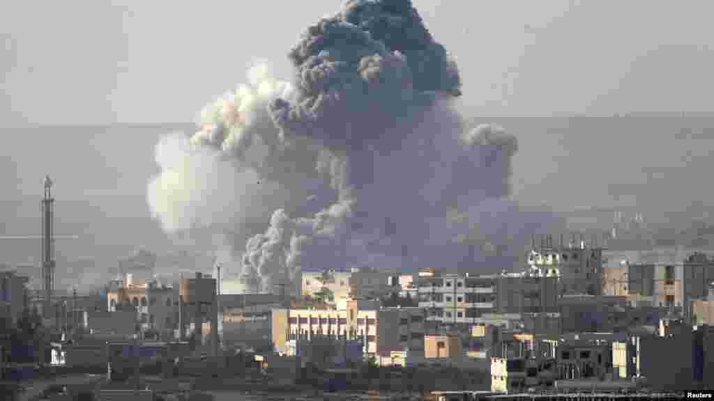 Smoke rises from the Syrian town of Kobani, seen from near the Mursitpinar border crossing on the Turkish-Syrian border in the southeastern town of Suruc in Sanliurfa province, Oct. 14, 2014.