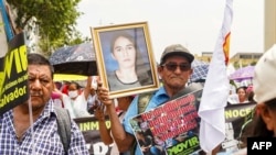 Una manifestante sostiene una fotografía de su hija, que ha sido encarcelada injustamente en el régimen de excepción, en una protesta contra el ingreso a la Asamblea Legislativa durante una manifestación del Primero de Mayo (Día del Trabajo) en San Salvador el 1 de mayo de 2024.