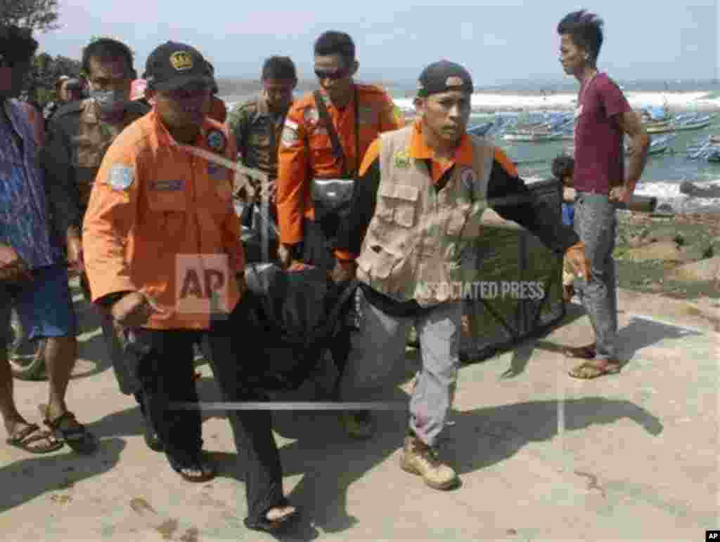 Rescuers carry the body of a victim killed after a boat carrying asylum seekers sank off West Java, Indonesia, July 24, 2013. 