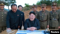 Le leader communiste nord-coréen Kim Jong-Un affiche un large sourire après un tir réussi d’un missile à longue portée, Corée du Nord, 12 mars 2017.