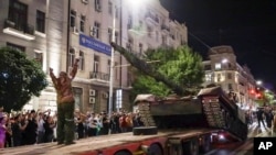 Los miembros de la compañía militar Wagner Group cargan su tanque en un camión en una calle de Rostov-on-Don, Rusia, el sábado 24 de junio de 2023, antes de abandonar un área en la sede del Distrito Militar del Sur.