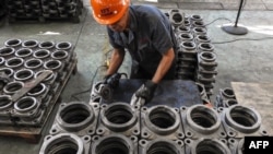 中国江苏省连云港，一名工人在工厂里加工传动部件。