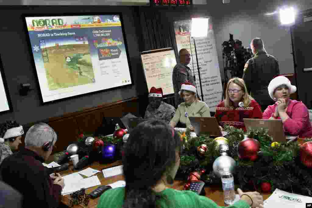 2012年12月24日,圣诞节前夕,在北美航空航天防务司令部(NORAD)的科罗拉多州斯普林斯的彼得森空军基地 ,志愿者接听孩子们打来的电话。儿童们询问圣诞老人到了哪里,何时把礼物送到他们家。志愿者回答他们。每年圣诞节前夜,NORAD的一千多名志愿者处理来自世界各地的儿童的十万多个电话,而NORAD则持续地预报圣诞老人送礼的行程。