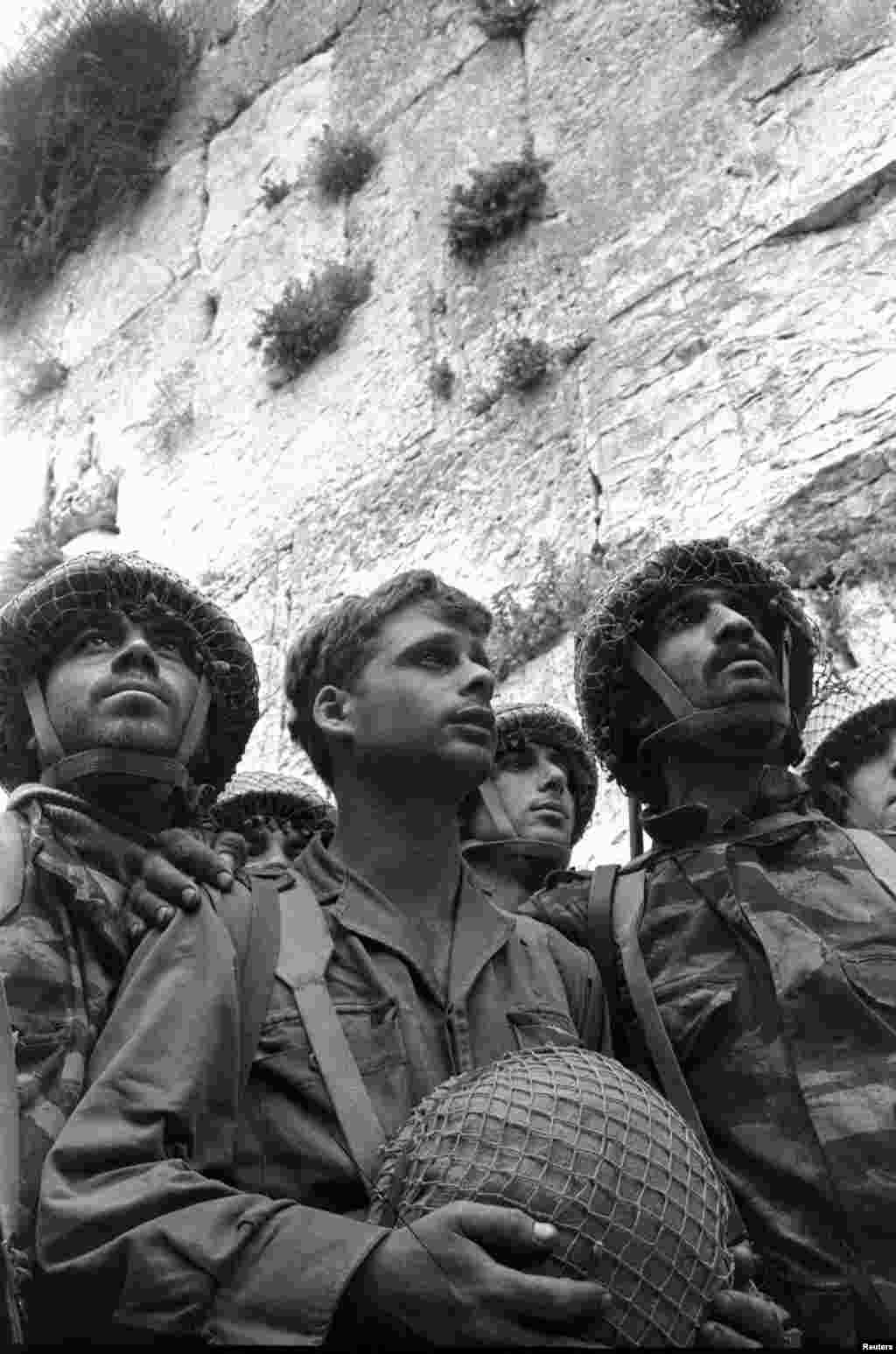 Isroillik askarlar Quddusning Eski shahar qismiga kirib borayapti / Israeli paratroopers stand in front of the Western wall in Jerusalem's Old City in June 1967 after it was captured during the Middle East War.