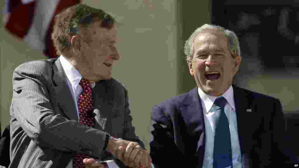 L'ancien président George H. W. Bush serre la main de son fils, l'ancien président George W. Bush lors de l'inauguration du Centre George W. Bush présidentielle, Dallas, le jeudi 25 Avril 2013.