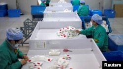 上海一家工廠的工人在生產線上趕製口罩。（2020年1月31日）
