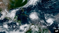 In this GOES-16 geocolor image satellite image taken Thursday, Sept. 7, 2017, the eye of Hurricane Irma, center, is just north of the island of Hispaniola, with Hurricane Katia, left, in the Gulf of Mexico, and Hurricane Jose, right, in the Atlantic Ocean. 