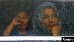 Migranti gledjau kroz prozor voza na železničkoj stanici u gradu Biske u Mađarskoj, 4. septembra 2015.