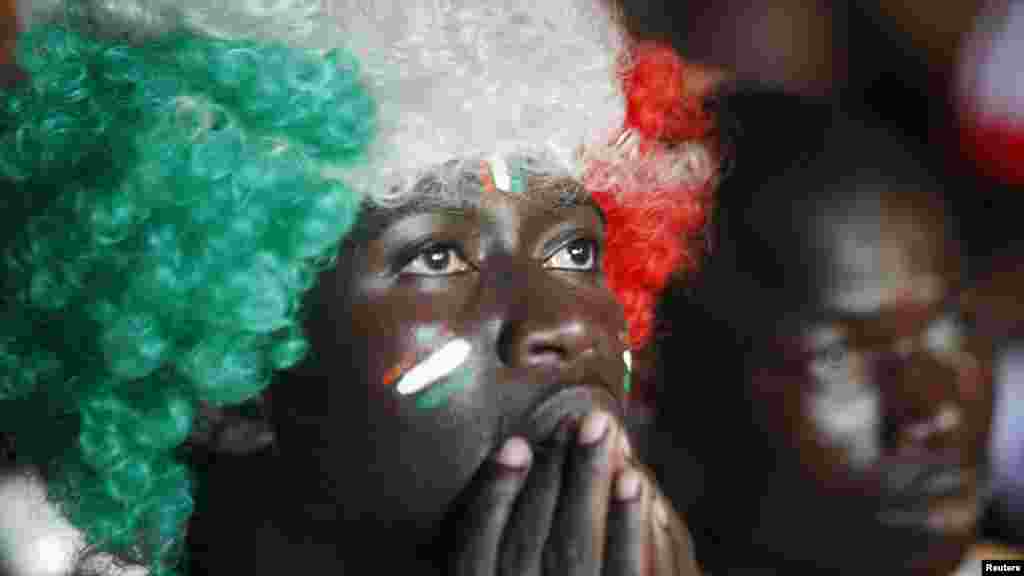 Fans of Ivory Coast soccer team watch a telecast of their team's African Nations Cup final against Ghana on a big screen on a street of Abidjan February 8, 2015. REUTERS/Luc Gnago (IVORY COAST - Tags: SPORT SOCCER SOCIETY) - RTR4OQBM