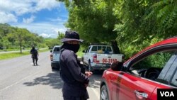 ARCHIVO - Un agente de las fuerzas del orden de El Salvador durante una parada de tráfico, en agosto de 2020.