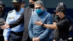 前洪都拉斯總統埃爾南德斯戴著手銬，在首都特古西加爾巴的一處空軍基地等待上飛機被引渡至美國。(2022年4月21日)